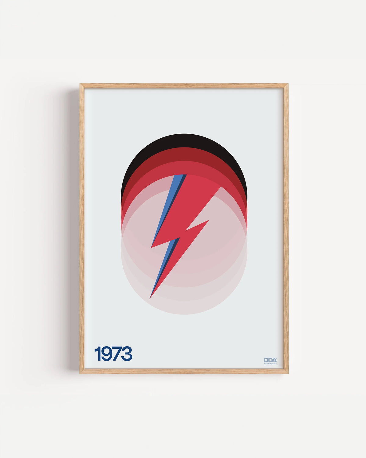 Poster 1973 di DDA in cornice rovere su parete bianca: un fulmine rosso e blu davanti a cerchi che sfumano dal nero al rosa.