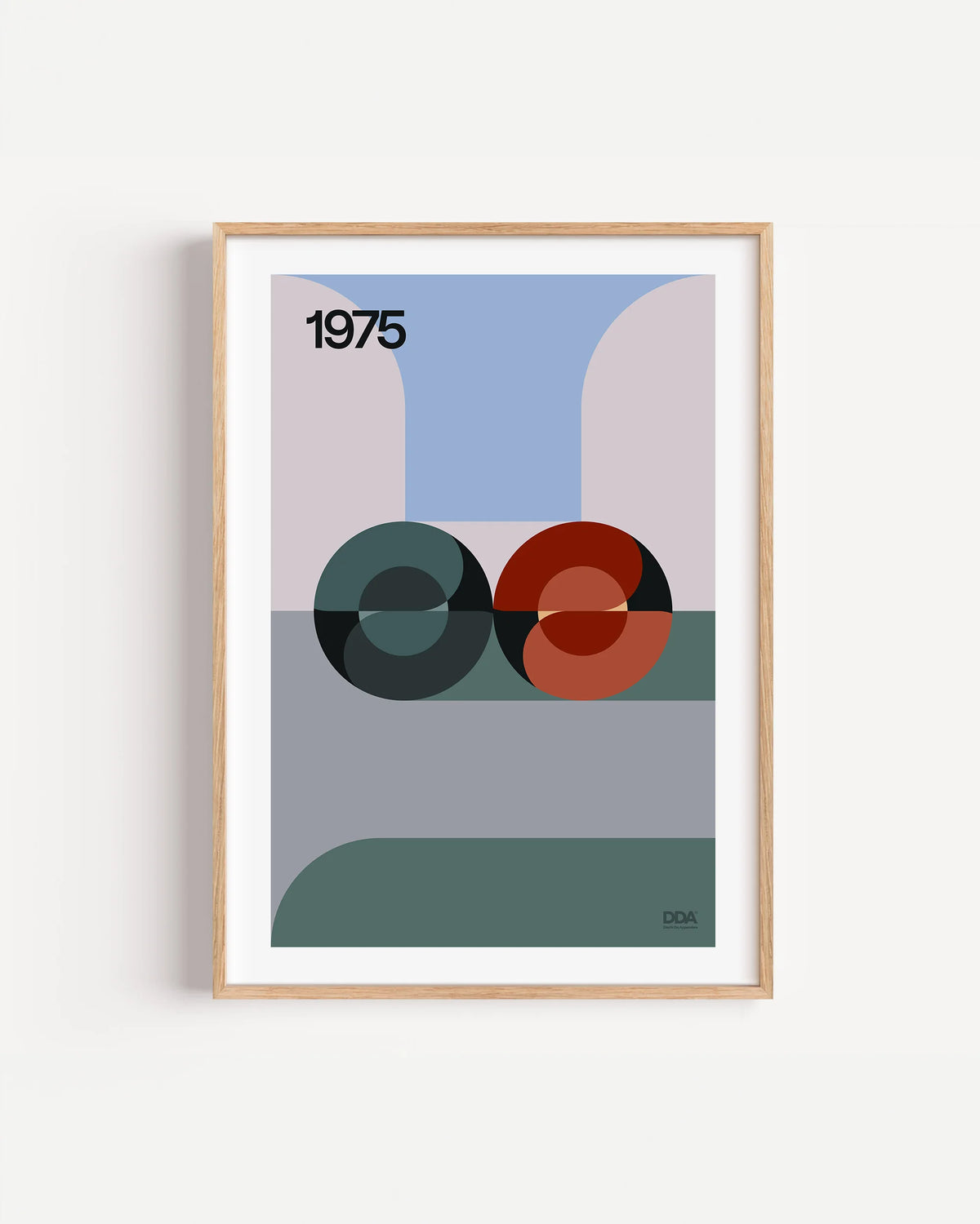 Poster 1975 di DDA in cornice rovere su parete bianca: due sfere a spirale, una verde scuro e una rossa, su fasce di grigio, viola e verde.