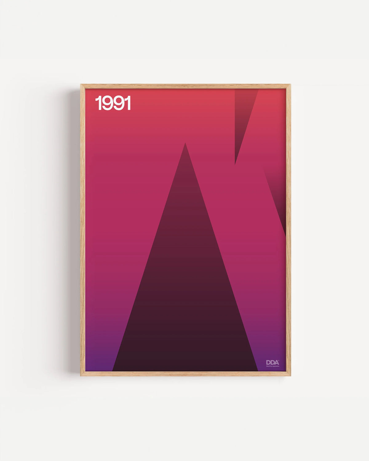 Poster 1991 di DDA in cornice rovere su parete bianca: un triangolo scuro che sale su un fondo rosso e viola sfumato.