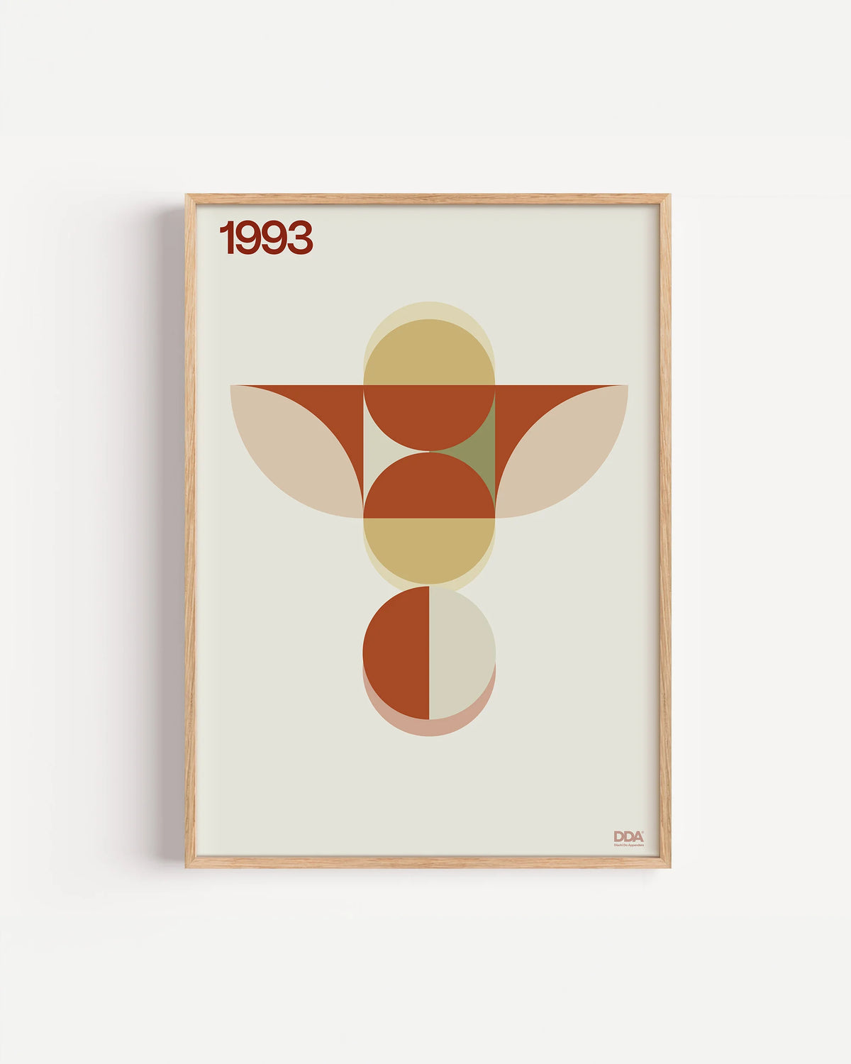 Poster 1993 di DDA in cornice rovere su parete bianca: una figura verticale di cerchi e semicerchi arancio e beige, con due ali a foglia.