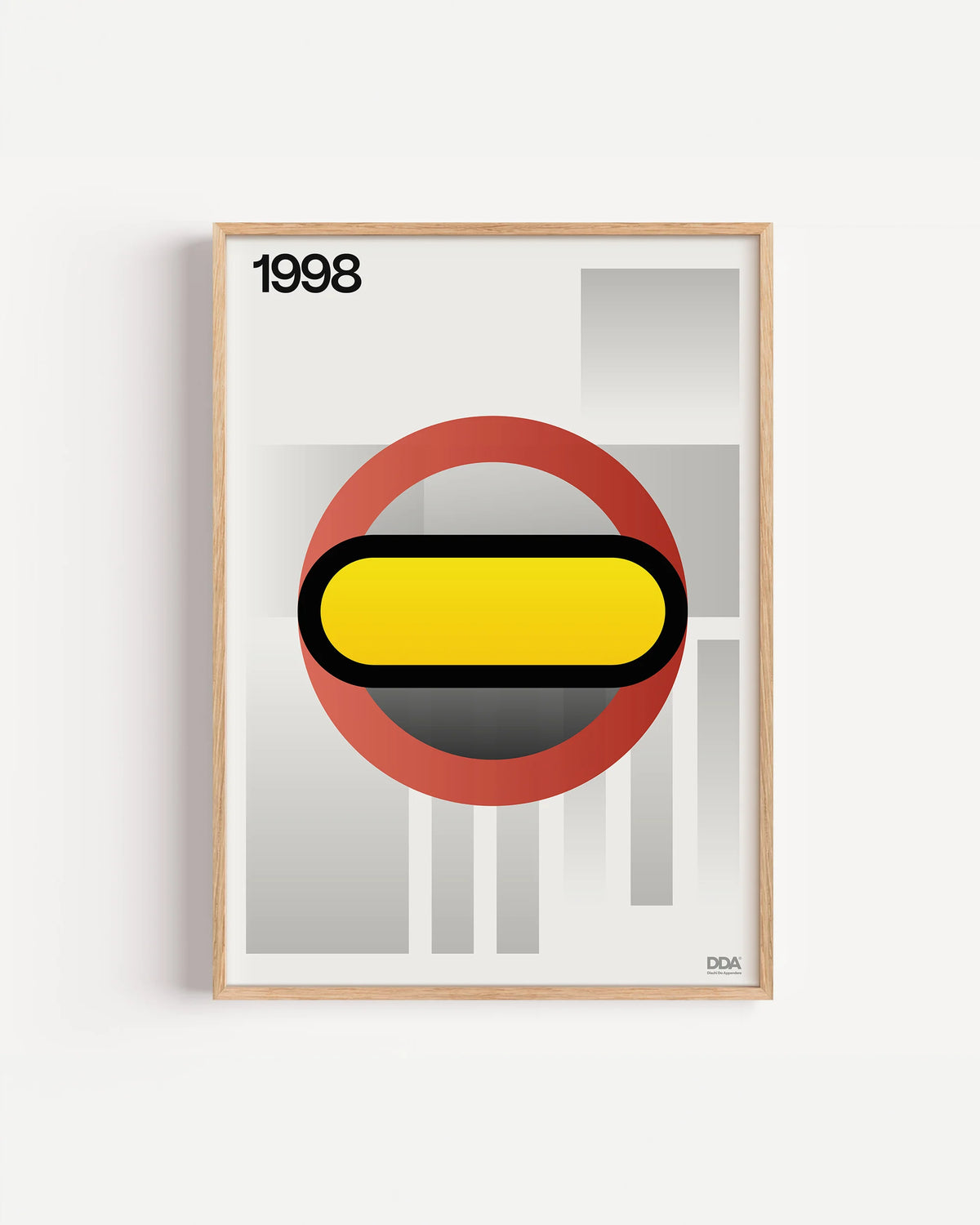 Poster 1998 di DDA in cornice rovere su parete bianca: un anello rosso con una capsula gialla al centro, su fondo chiaro con barre grigie.